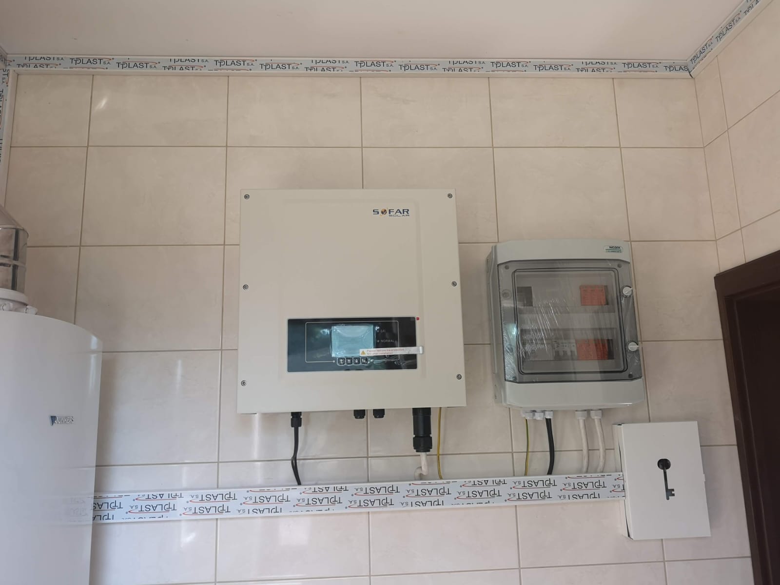Falownik instalacji fotowoltaicznej i rozdzielnica na ścianie.